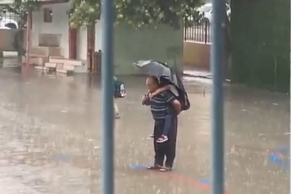 Torununu sırtına aldı sağanak yağışın altında İstiklal Marşı'nı okudu